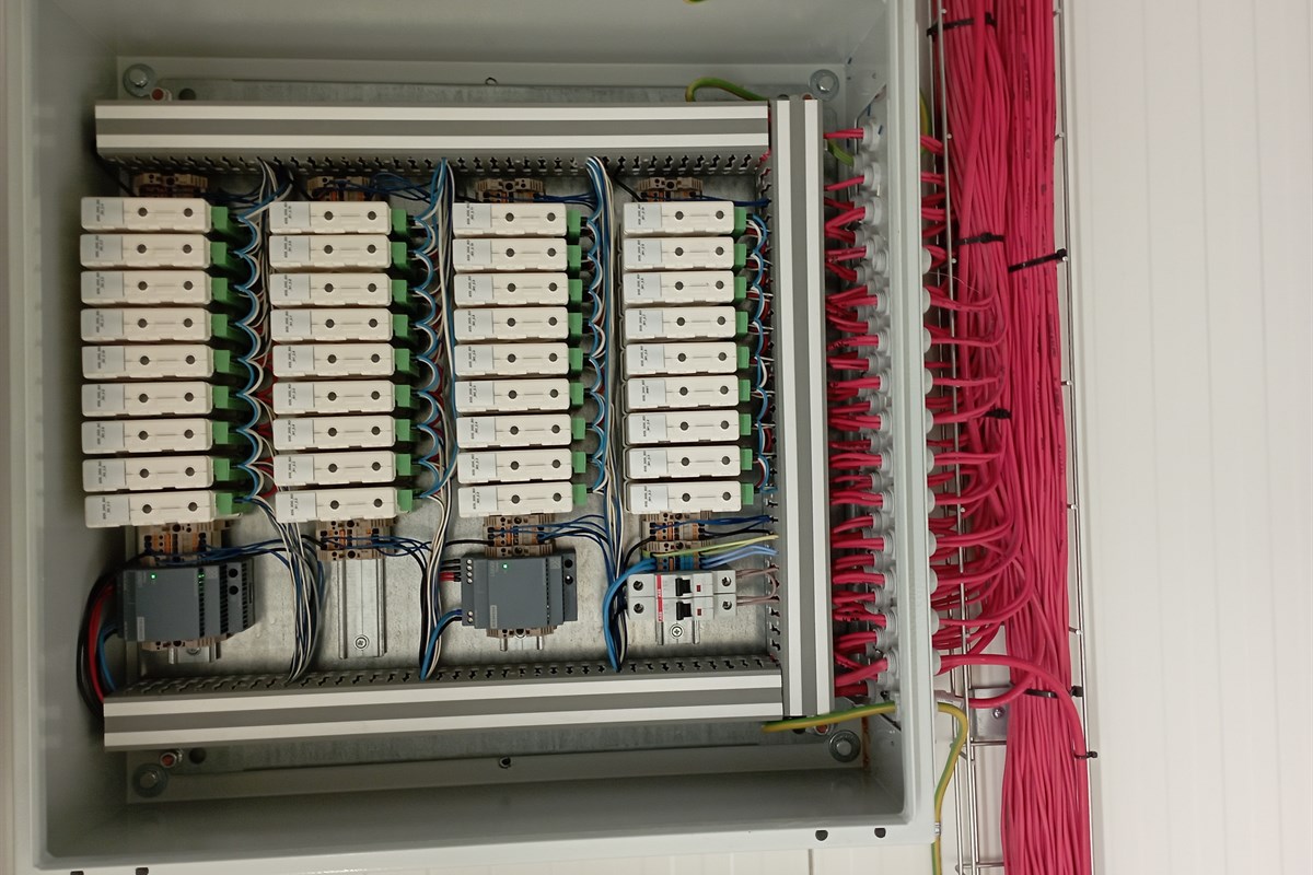 Technik diagnozujący szafę sterowniczą multimetrem